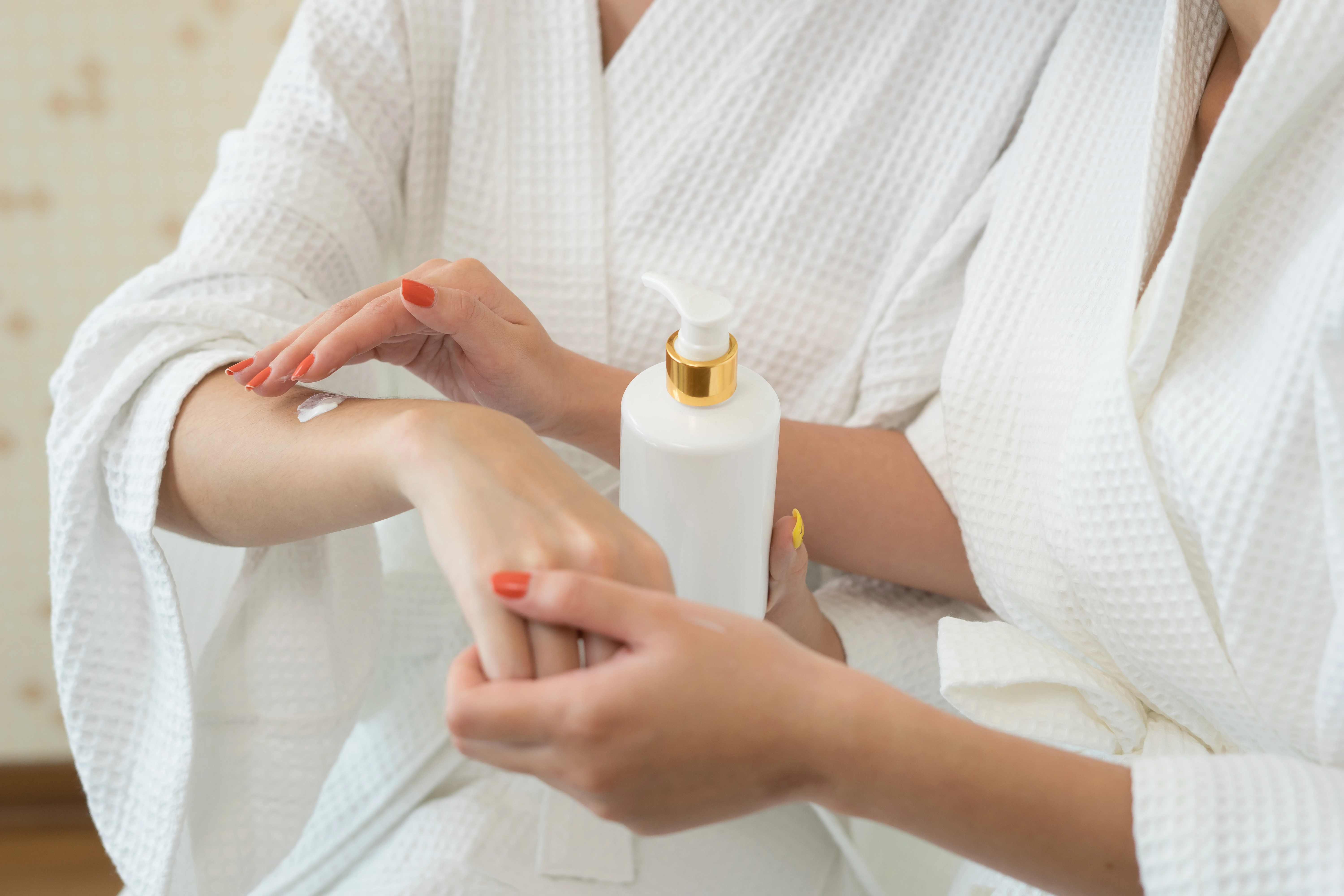 young-woman-applying-with-finger-white-moisturizing-cream-hand